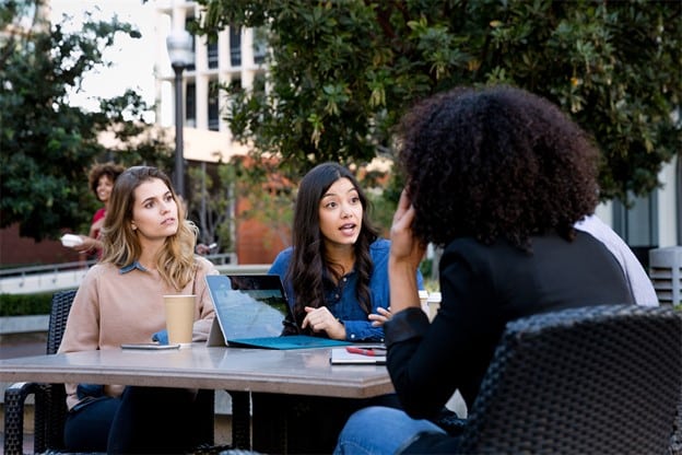 Image_Three-women-at-a-table-looking-at-a-tablet-computer. Create campaign impact by reaching the Workday Consumer