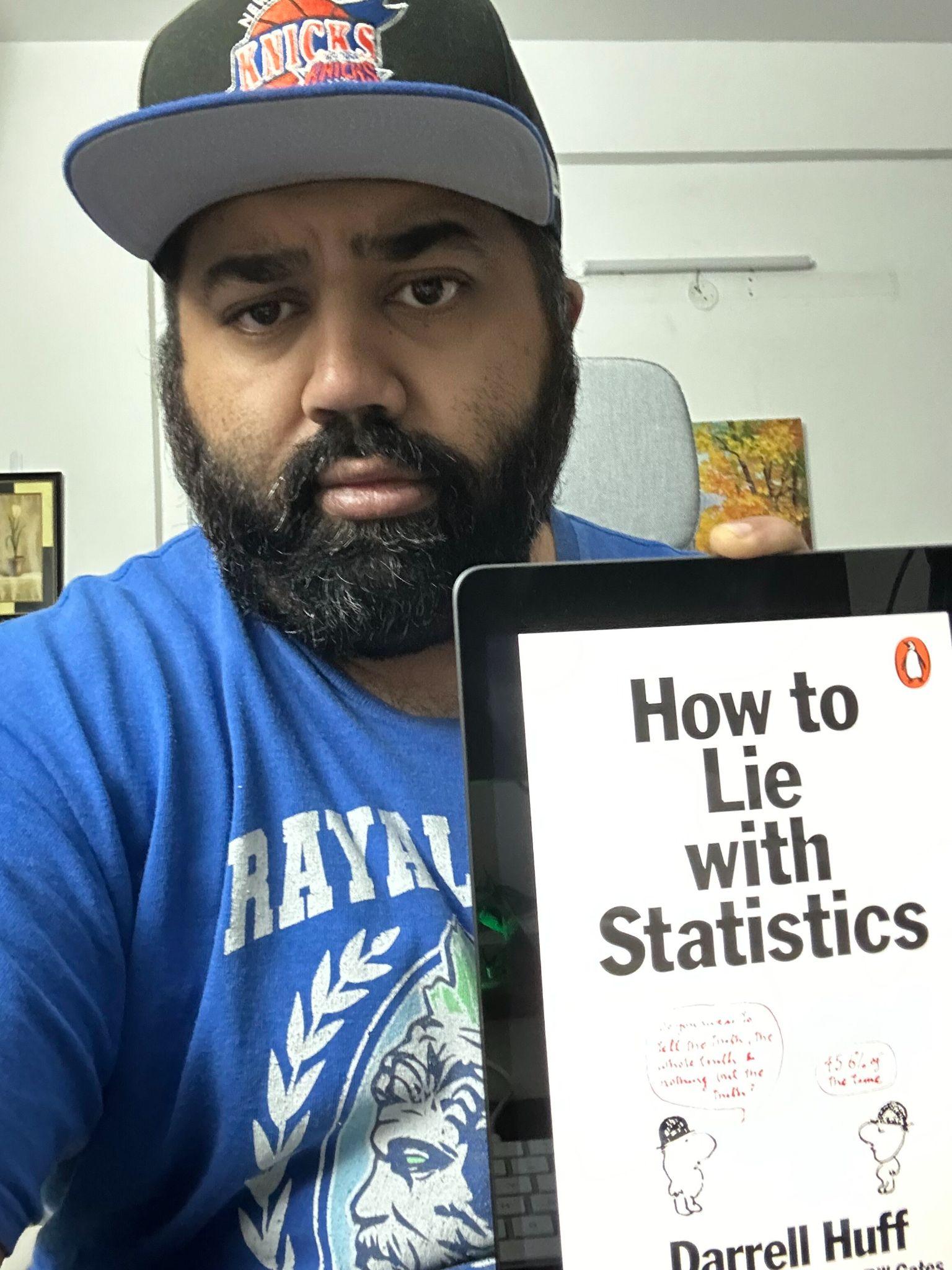 ashwin-holding-the-book-how-to-lie-with-statistics I Asked 26 Marketers for Their Best Marketing Books. Here's What They Recommend